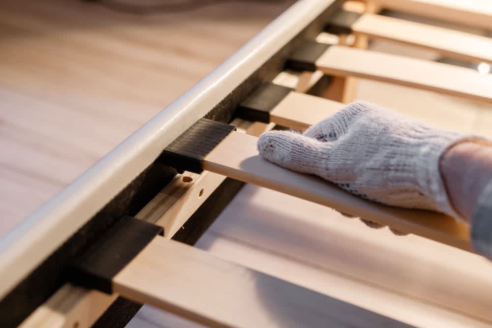 stock photo of someone assembling a bed frame