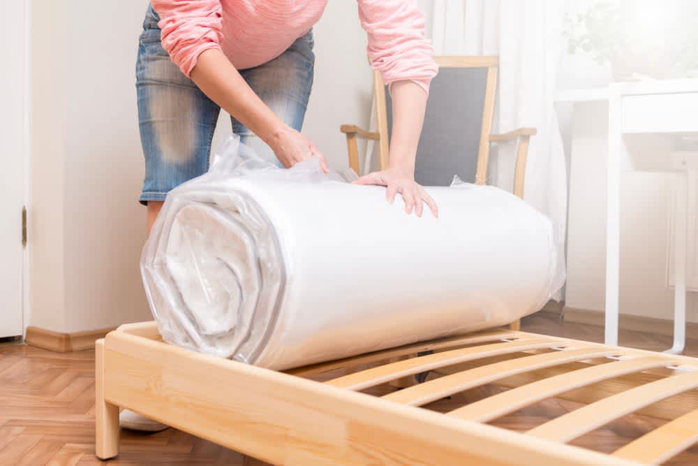 stock photo of a woman packing a mattress