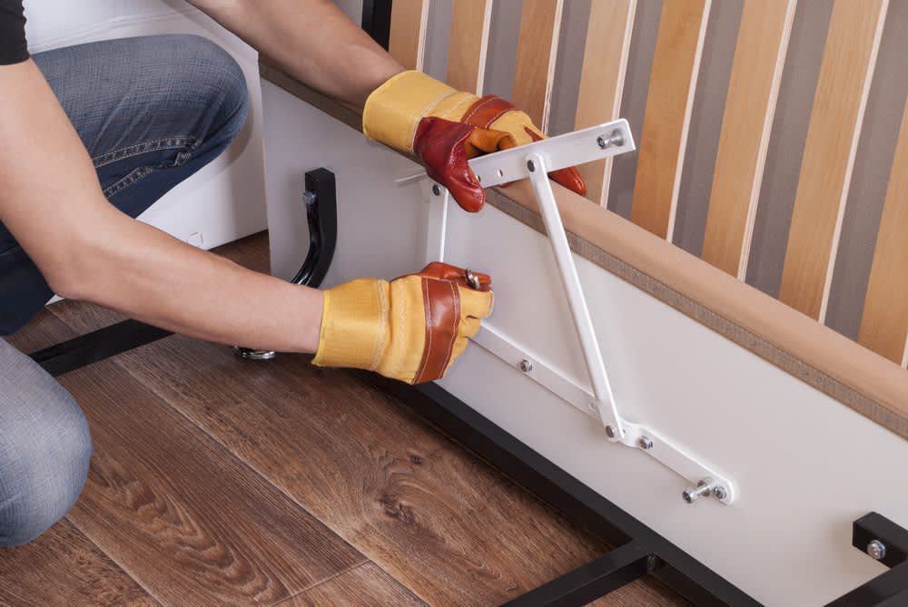 stock photo of a person adjusting bed frame