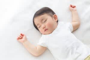 stock photo of a baby sleeping on back