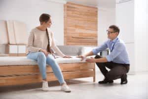 stock photo of a saleman showing a young woman a mattress in a store