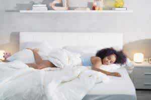stock photo of a young woman sleeping on mattress