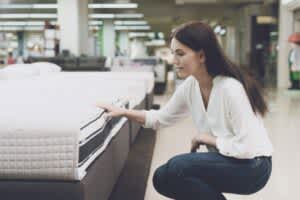 stock photo of a woman testing mattress at a store
