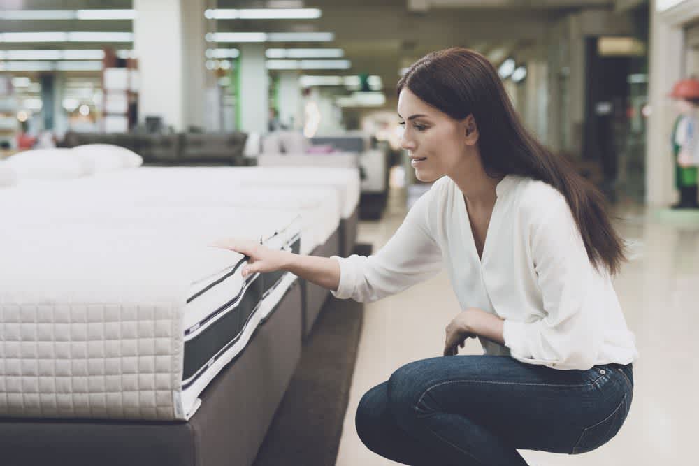stock photo of a woman testing mattress at a store