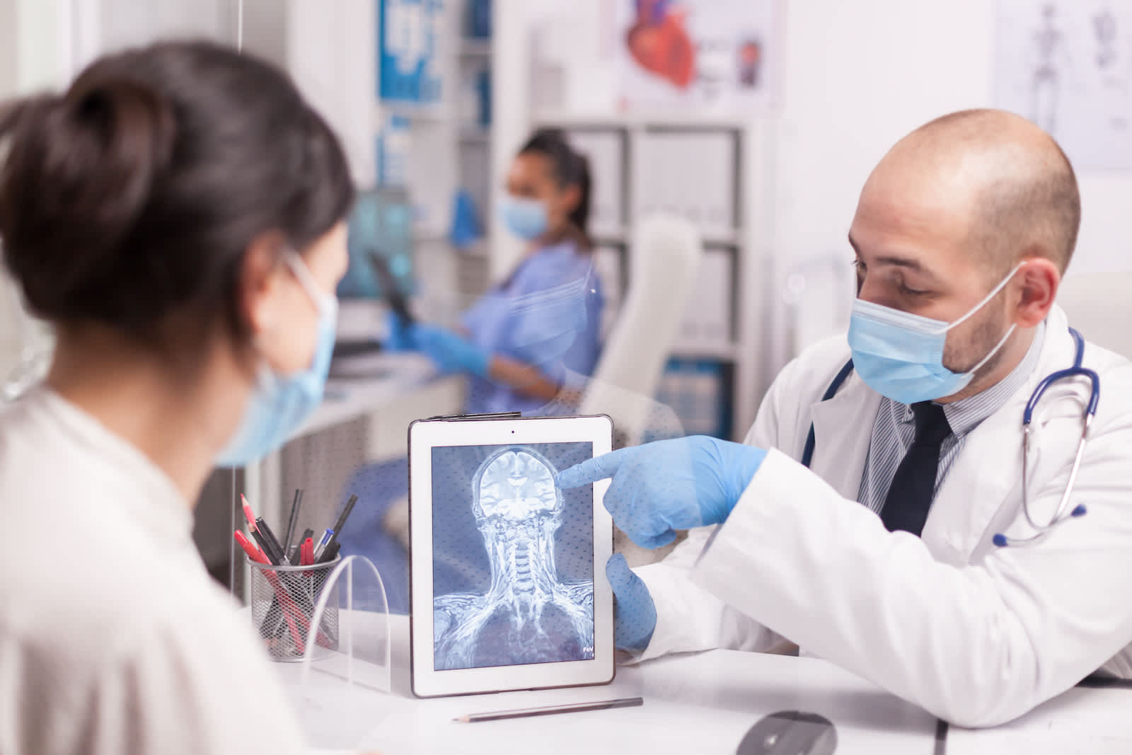 A doctor examines a brain scan with a patient