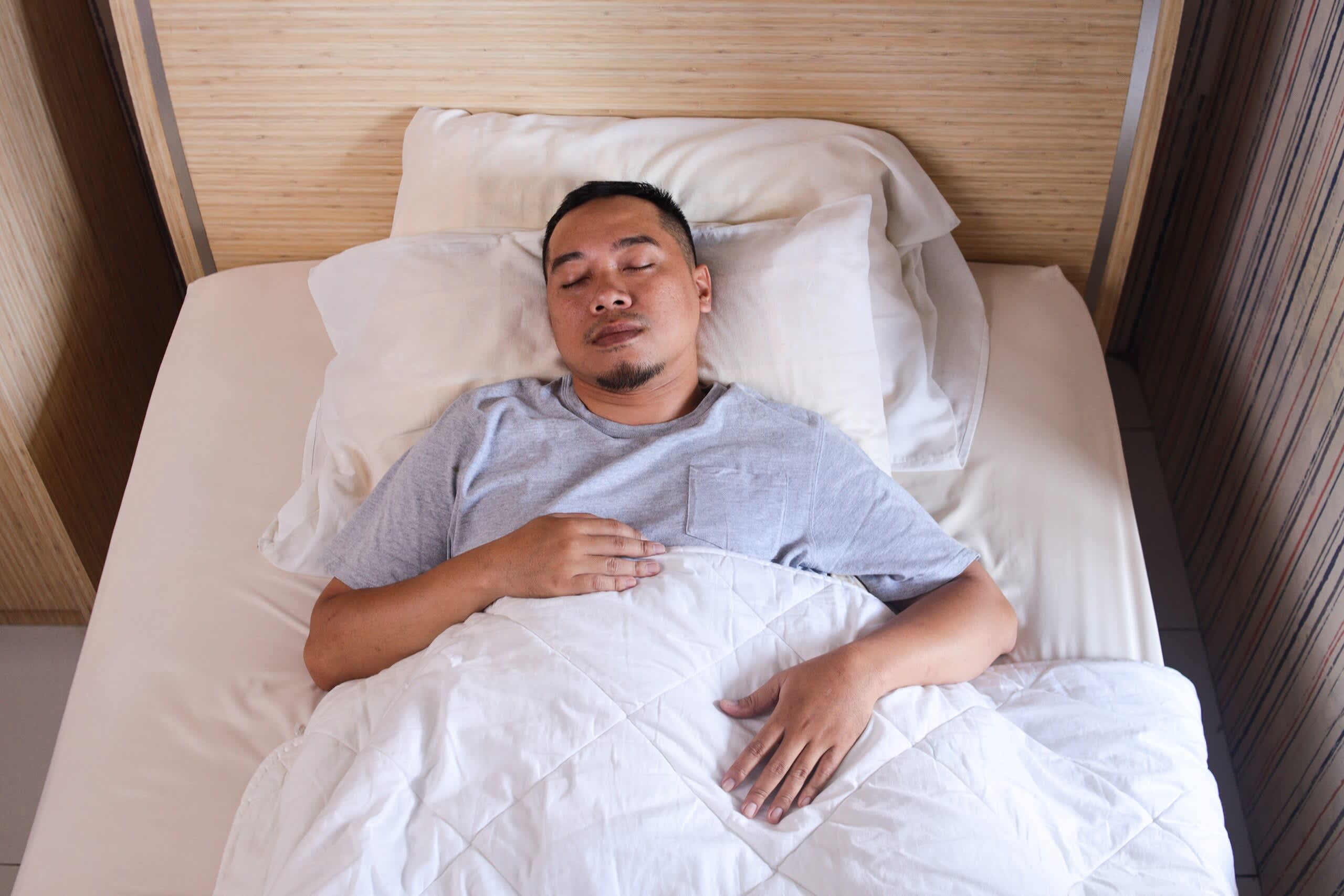 Asian,Young,Man,Sleeping,In,White,Bedding