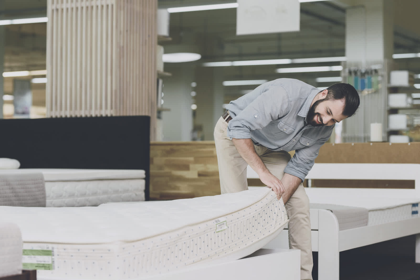 A man examines a mattress