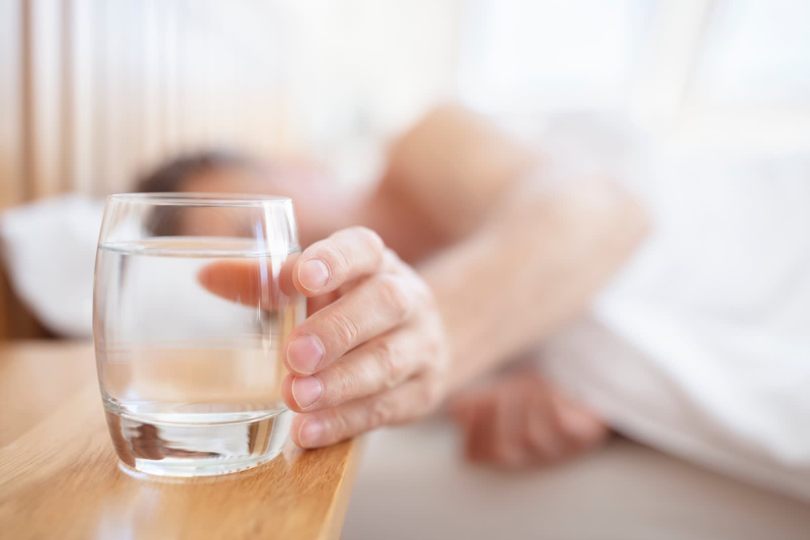 person reaching for glass of water