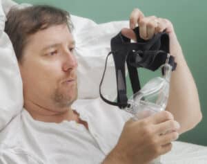 man examines a cpap mask