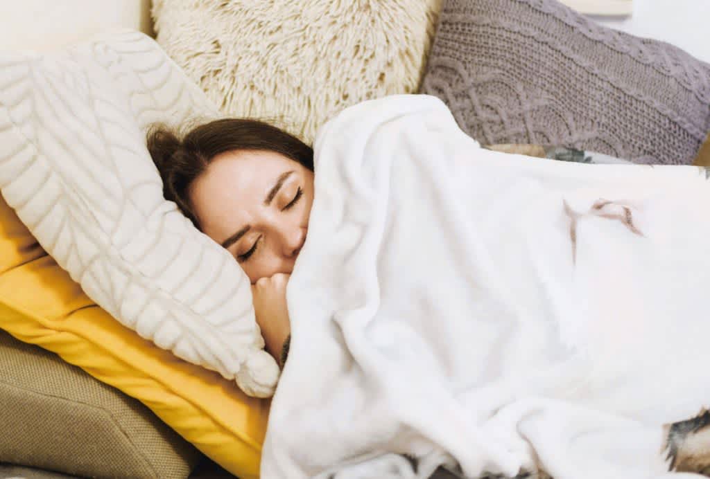 Fotografia do Stock: Tired young woman sleeping well on the side in bed  with white sheets, resting after sleepless night. Female student lying in  bed until late morning. Getting enough sleep concept.